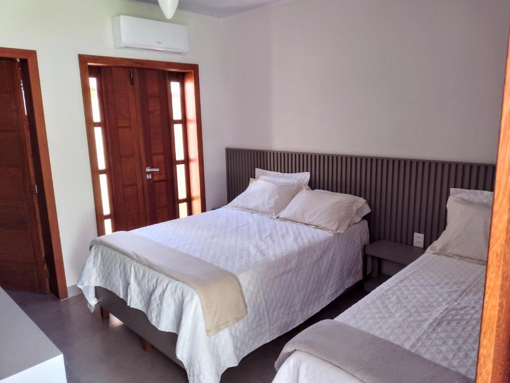 een slaapkamer met 2 bedden en een raam bij Pousada Pantanal in Prado