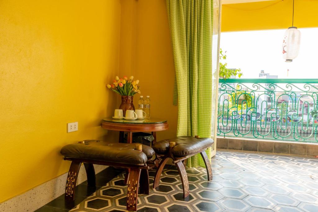 Habitación con 2 taburetes, mesa y ventana en Our HomeStay, en Hai Phong