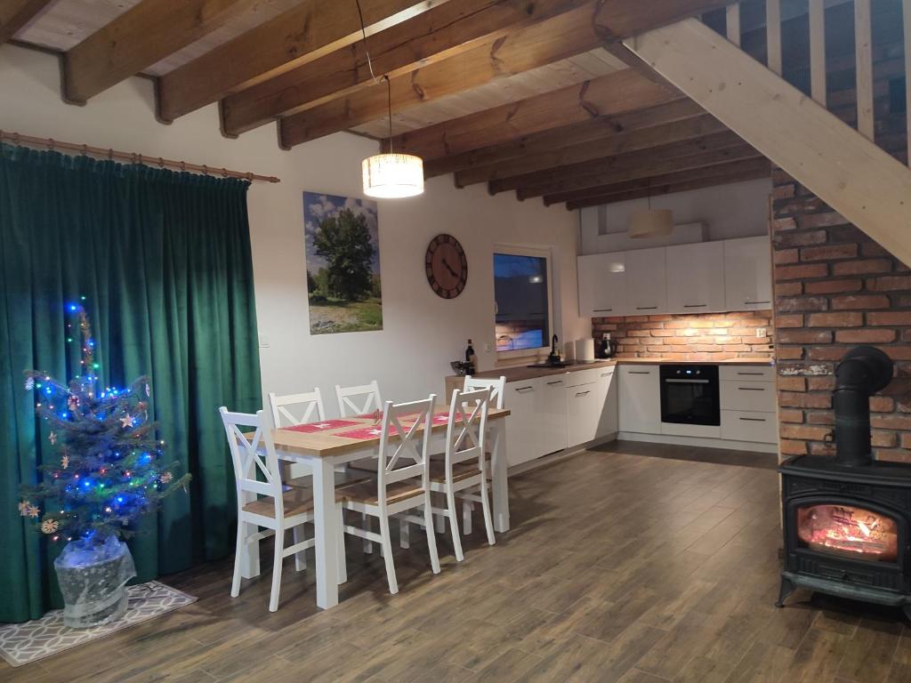 a kitchen and dining room with a table and a christmas tree at Dzika Polana in Duszniki Zdrój