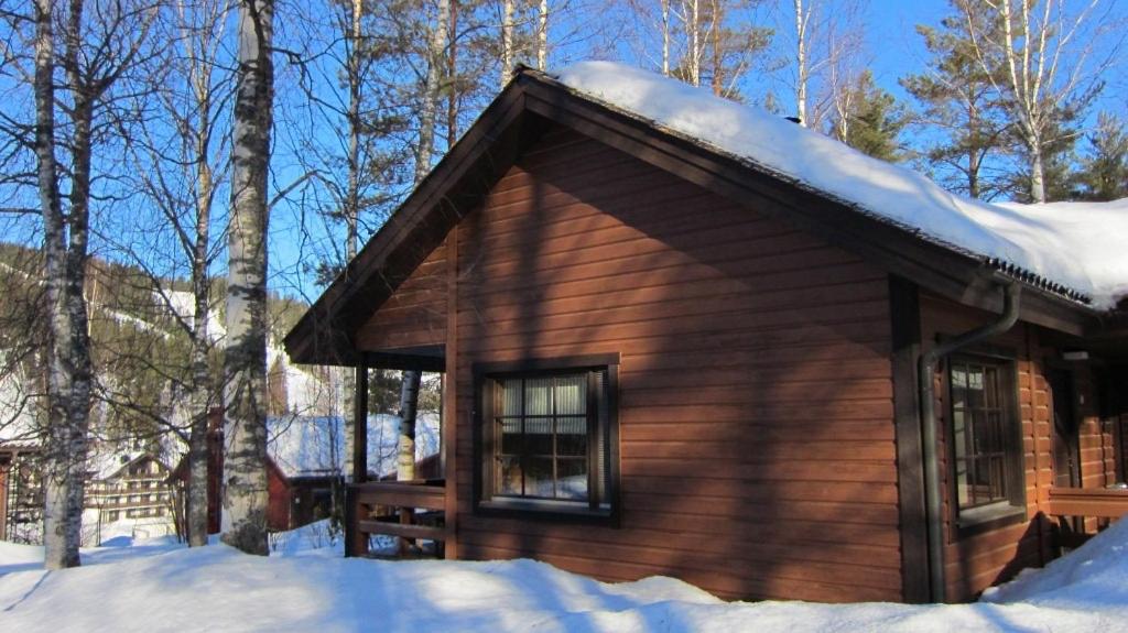 una cabaña de madera con nieve encima en Tahkon mökki en Tahkovuori