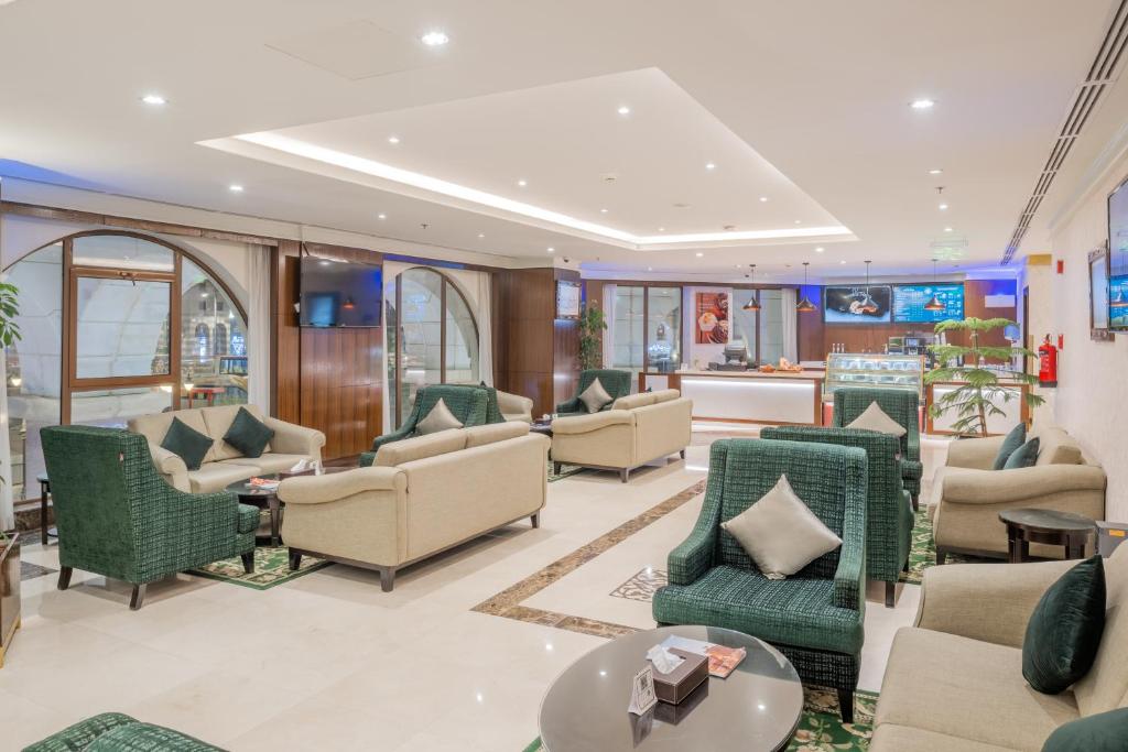 a lobby of a hotel with chairs and tables at Taiba Madinah Hotel in Medina