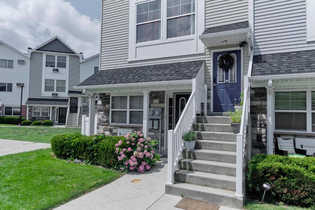 a white house with a blue door and stairs at Waterfront Gem Duplex 3 Bedroom 2Floor in Whitestone Bronx Free parking in College Point