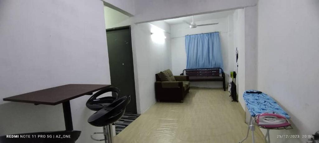 Kampong TelokにあるMY HOMESTAY PANGSAPURI SUTERA 2のデスク、ソファ、テーブルが備わる客室です。