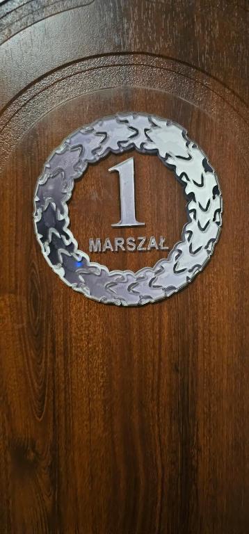uma placa numa porta de madeira com o número nela em Apartament Państwa Marszał em Radomsko