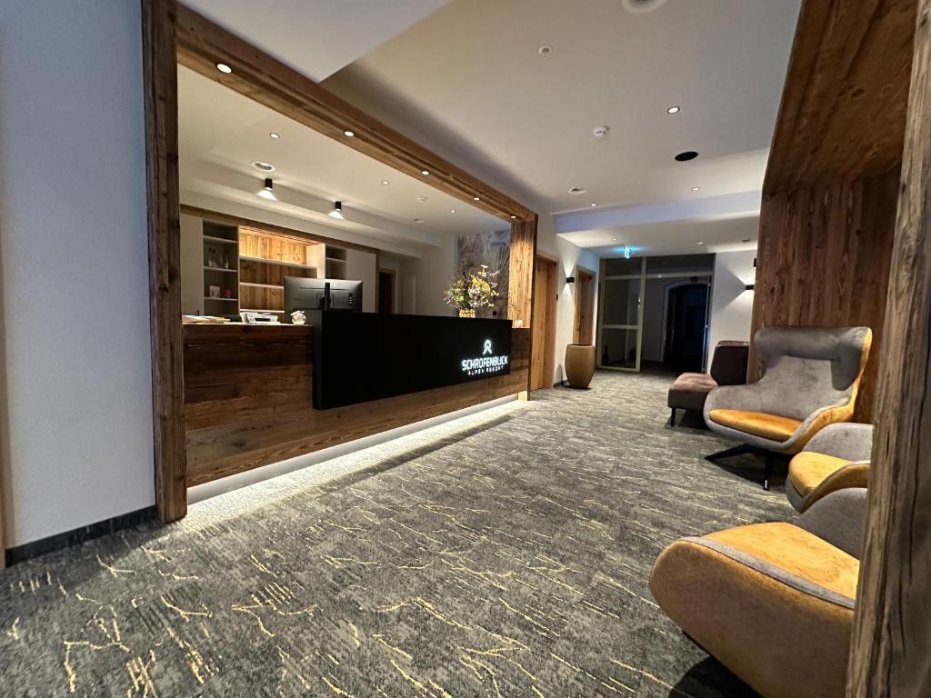 a lobby with a large flat screen tv and chairs at Resort Schrofenblick in Mayrhofen