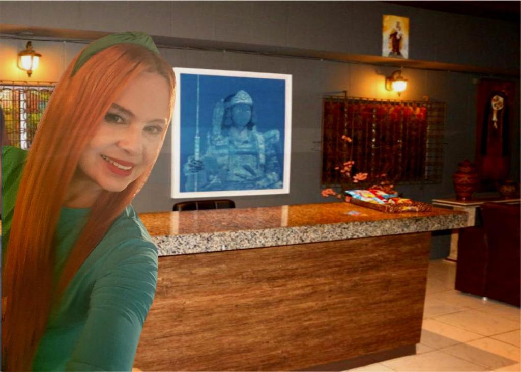 Pousada Portobello في ريسيفي: امرأة شعرها برتقال تجلس أمام منضدة