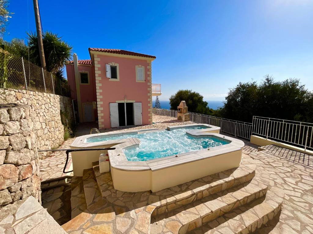 a hot tub in front of a house at Villa Kaminia Rose private pool & Jacuzzi in Ratzaklíon