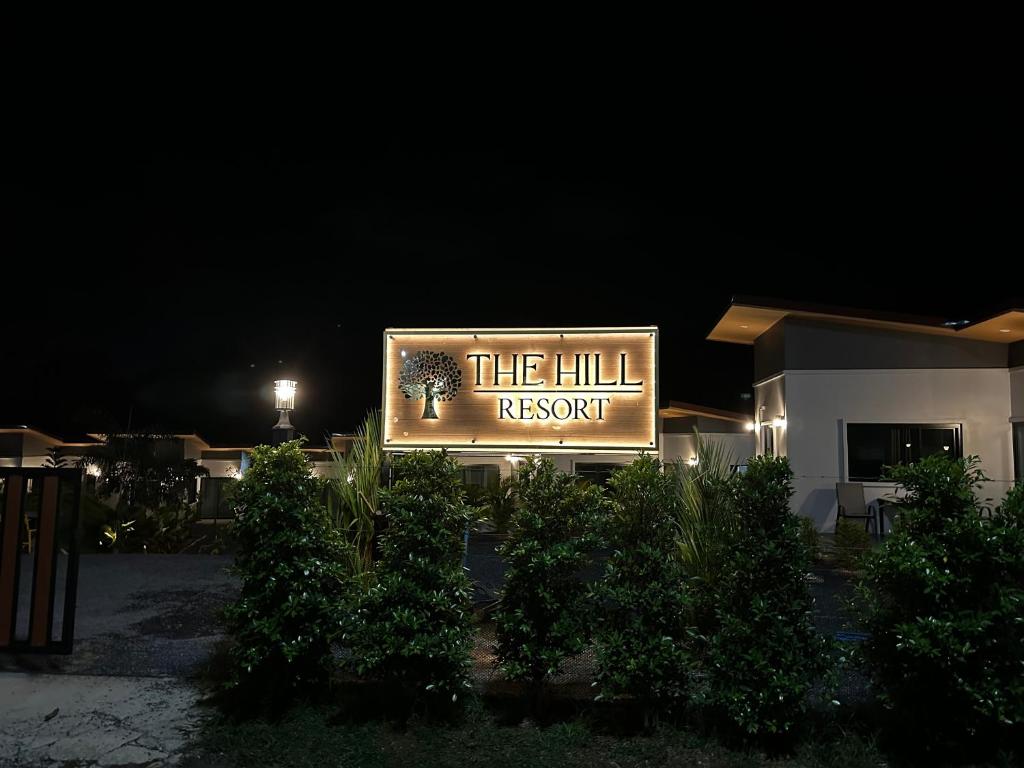 un cartel para el resort de la colina por la noche en The Hill resort Thalang, en Phuket