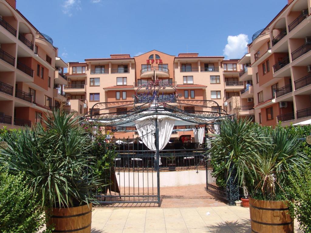 a view of a building with palm trees in front of it at Apart Hotel Efir in Sunny Beach
