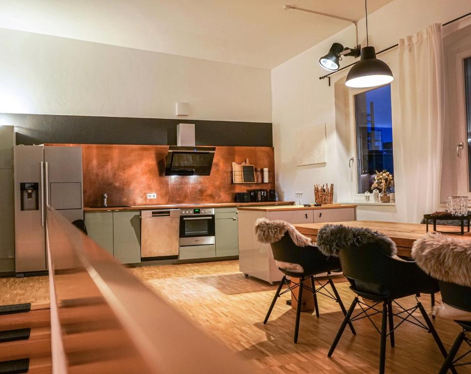 una cucina con tavolo e sedie in una stanza di Exklusives Stadthaus-Apartment am Staatstheather a Cottbus