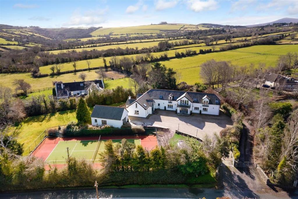 una vista aérea de una casa con pista de tenis en Winton Grove – for outdoor and tennis enthusiasts, en Kilmacanoge