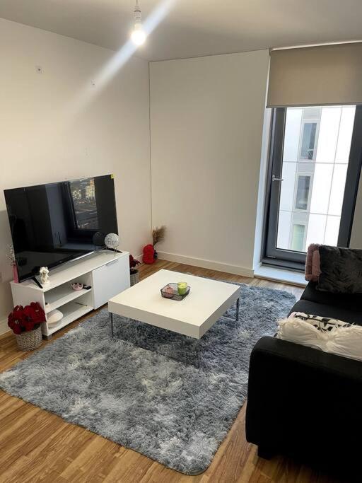 a living room with a coffee table and a tv at Cozie 1 BR apartment in Manchester
