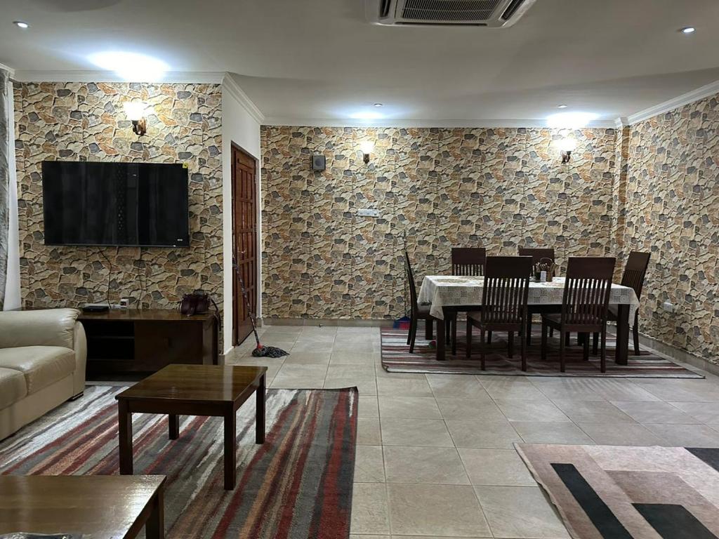 a living room with a table and a couch at Masaki - 2 Bedroom Apartment in Dar es Salaam