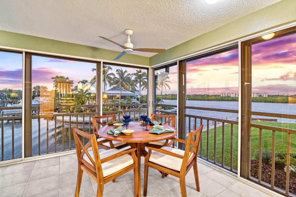 a dining room with a table and chairs and windows at Bayside Escape - 1345 in Siesta Key
