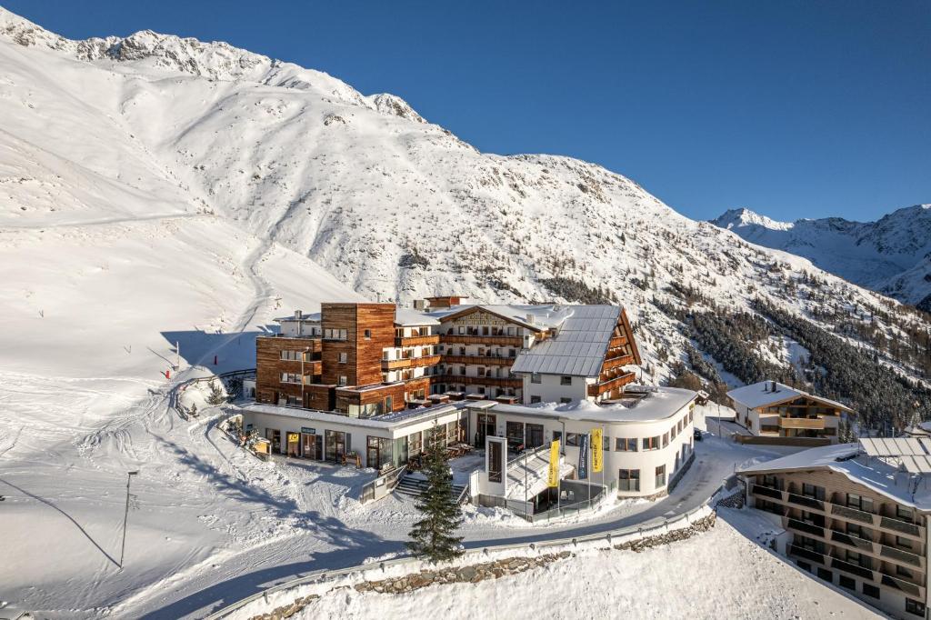 een gebouw bovenop een met sneeuw bedekte berg bij Hotel Hochsölden in Sölden