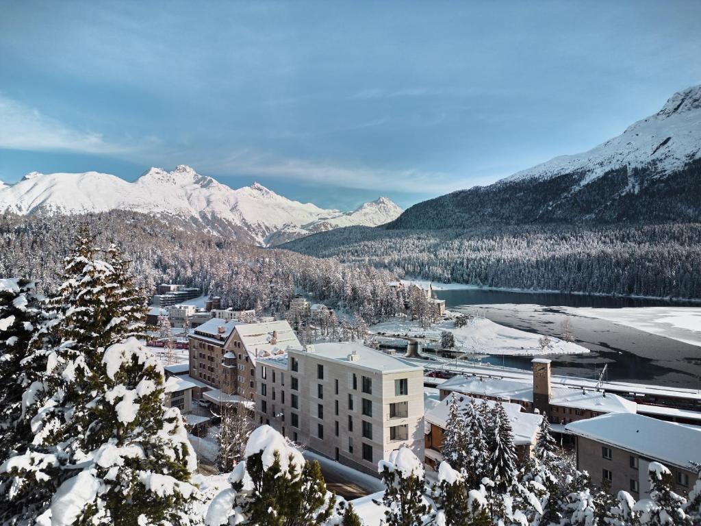 uma cidade na neve com montanhas ao fundo em Hotel GRACE LA MARGNA ST MORITZ em St. Moritz