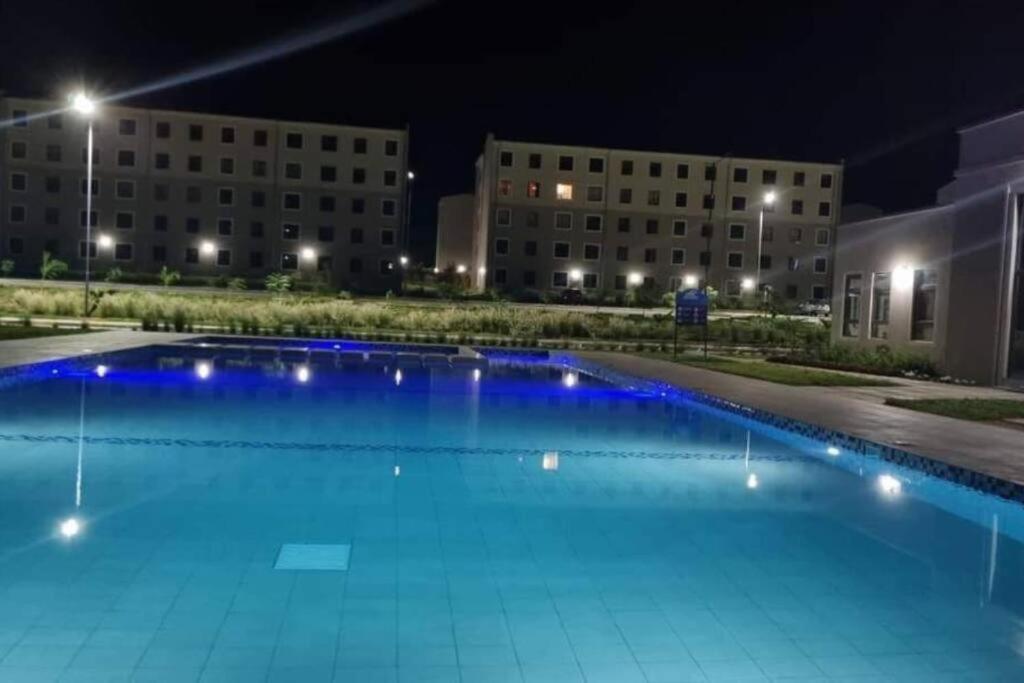 uma piscina à noite com edifícios ao fundo em Eleganza Suites em Kilifi