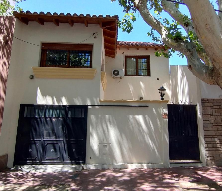 una casa blanca con una puerta y un garaje en Hostel Terminal en Barraquero