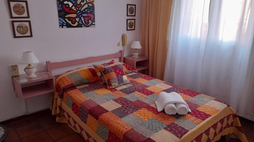 a bedroom with a bed with a towel on it at Posada de la Villa in Villa Gesell