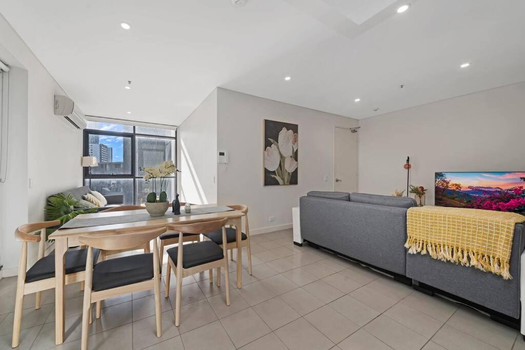 a living room with a table and a couch at Entire home with parking in Parramatta in Sydney