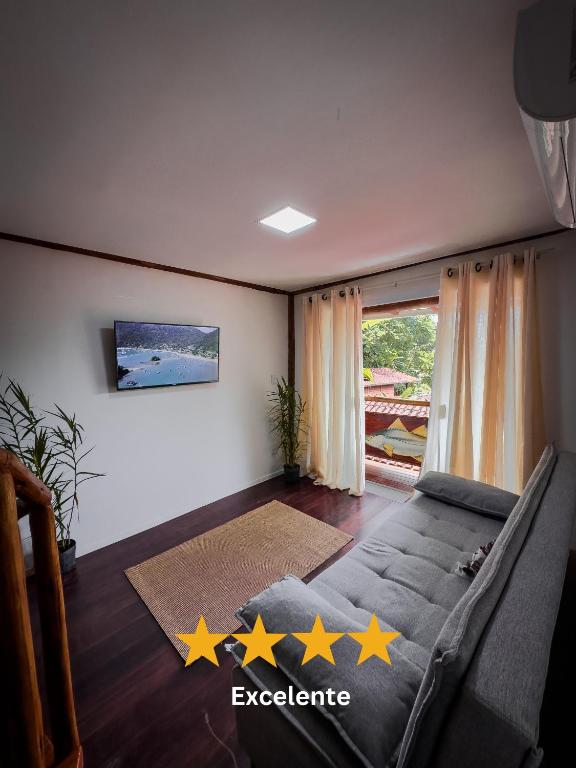 a living room with a couch with five stars on the floor at Flats do Pe na Areia in Abraão