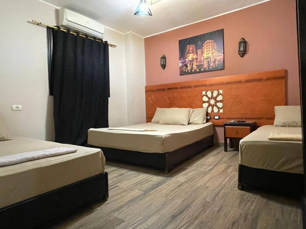 pokój hotelowy z dwoma łóżkami i oknem w obiekcie H100 Pyramids View w mieście Giza