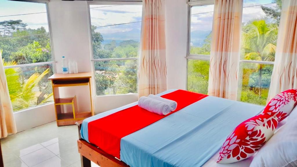 a bedroom with a bed and a large window at Blossom Rest in Kandy