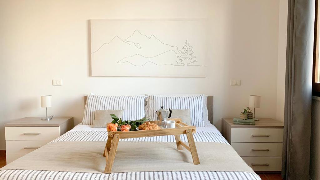 a bedroom with a bed with a tray of fruit on it at SulLago Appartamenti - Appartamento incantevole con Piscina in Castiglione del Lago