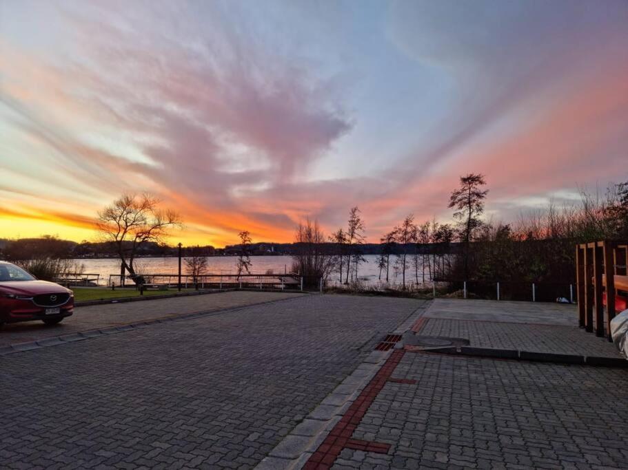 a parking lot with a sunset in the background at Departamento Costanera Villarrica in Villarrica