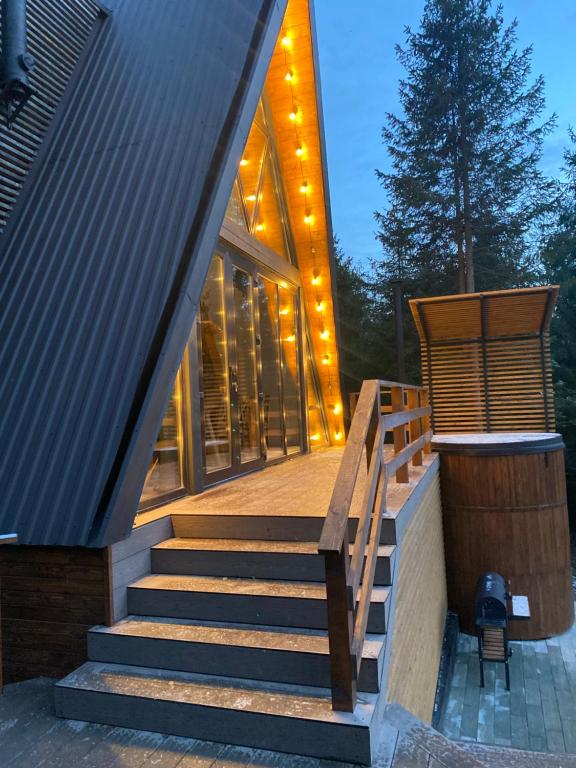 a house with stairs leading up to a building with lights at The Sunset Cabin будиночок з Чаном in Zhuraky