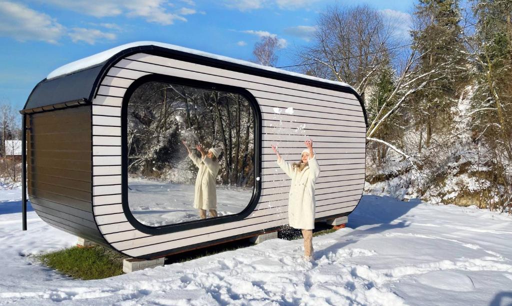 Eine Frau steht vor einem Fernseher im Schnee in der Unterkunft Tatry Panorama House in Zuberec