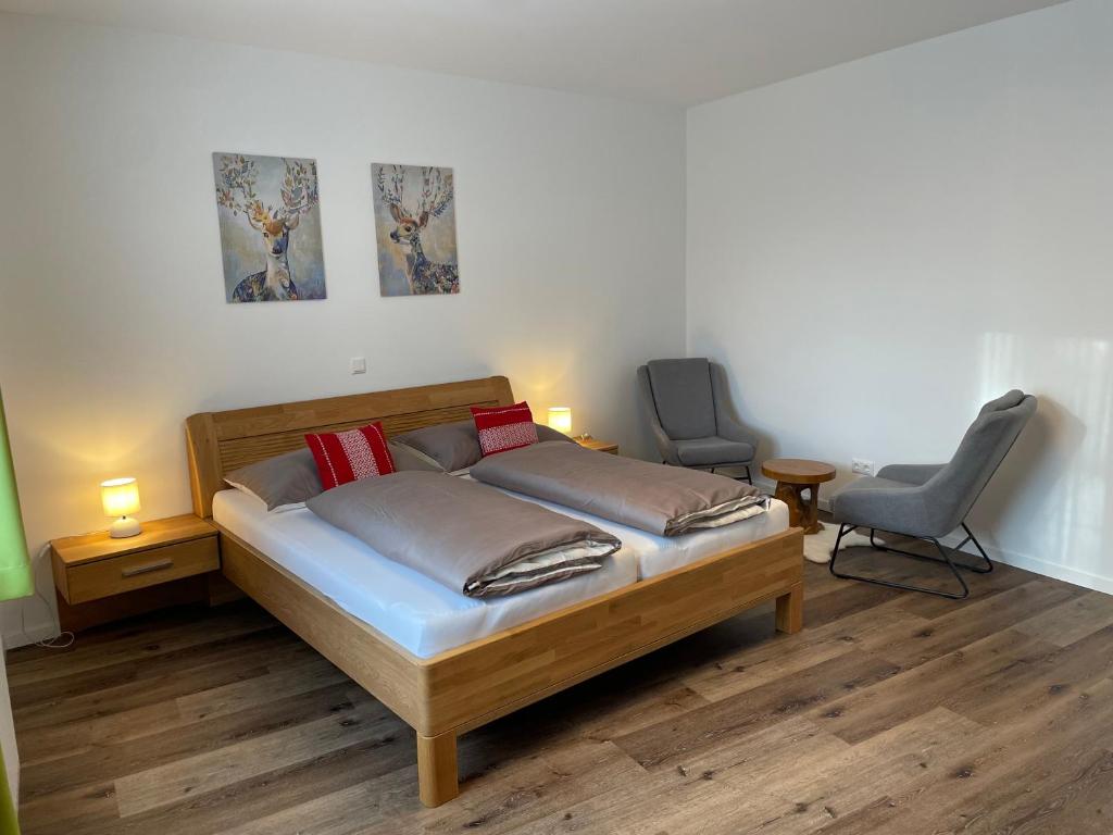 a bedroom with a bed and two chairs in it at Apartments am Mühlbach in Amstetten