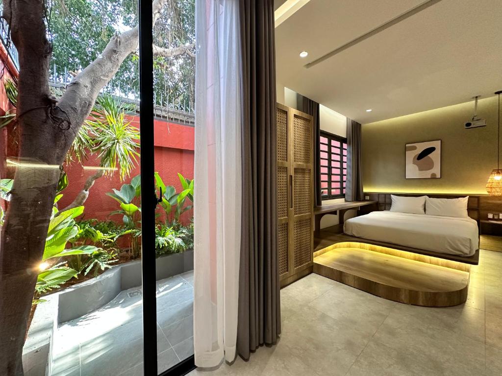 um quarto com uma cama e uma grande janela em KIN WANDER - Tân Phong em Ho Chi Minh