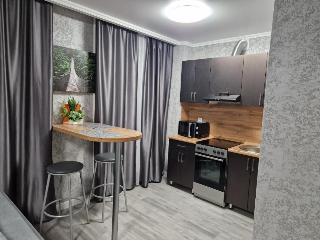 cocina con mesa y taburetes en una habitación en Апартаменты посуточно en Temirtaū