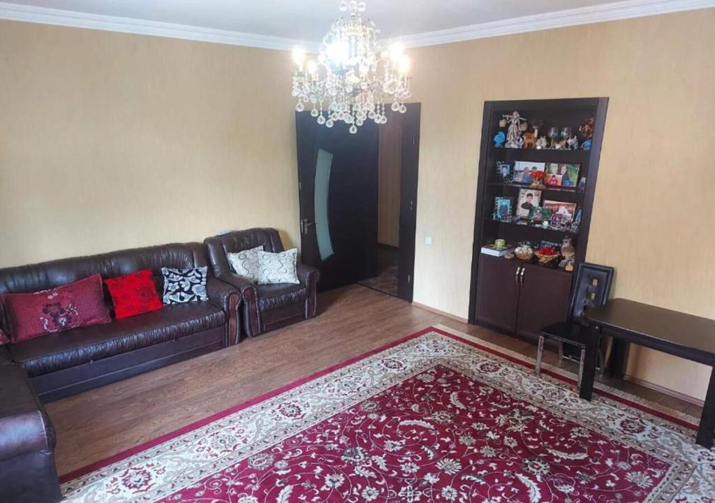 uma sala de estar com um sofá e um lustre em GOAL ApartmentS 2 em Tbilisi