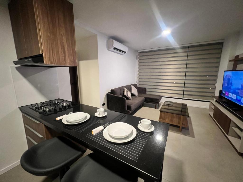 a kitchen and living room with a table and a stove at SCZ Apartment 1 Bedroom Suite Beautiful view in Santa Cruz de la Sierra