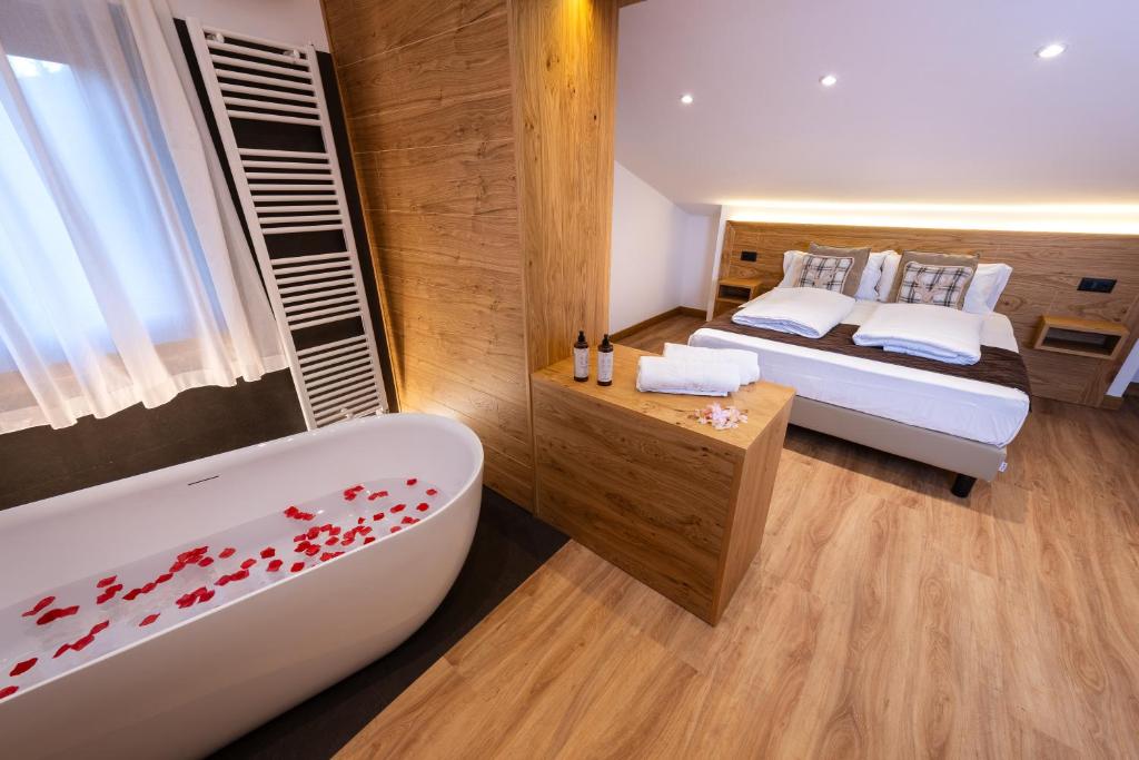 1 dormitorio con bañera, cama y bañera en Hotel Iris, en Pescasseroli