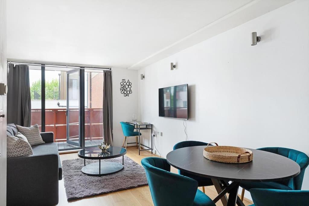 a living room with a couch and a table and chairs at Stylish apartment with underground parking in London