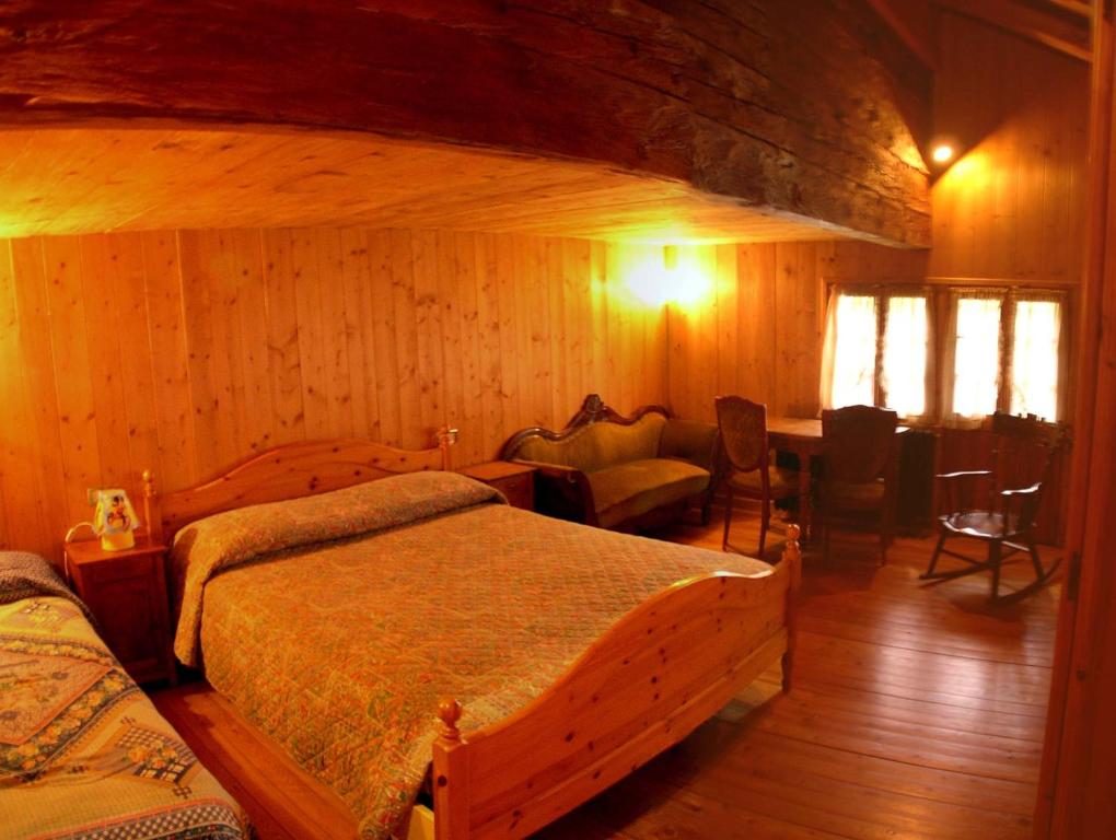 1 dormitorio con 2 camas y mesa. en Chalet Martina, en Macugnaga