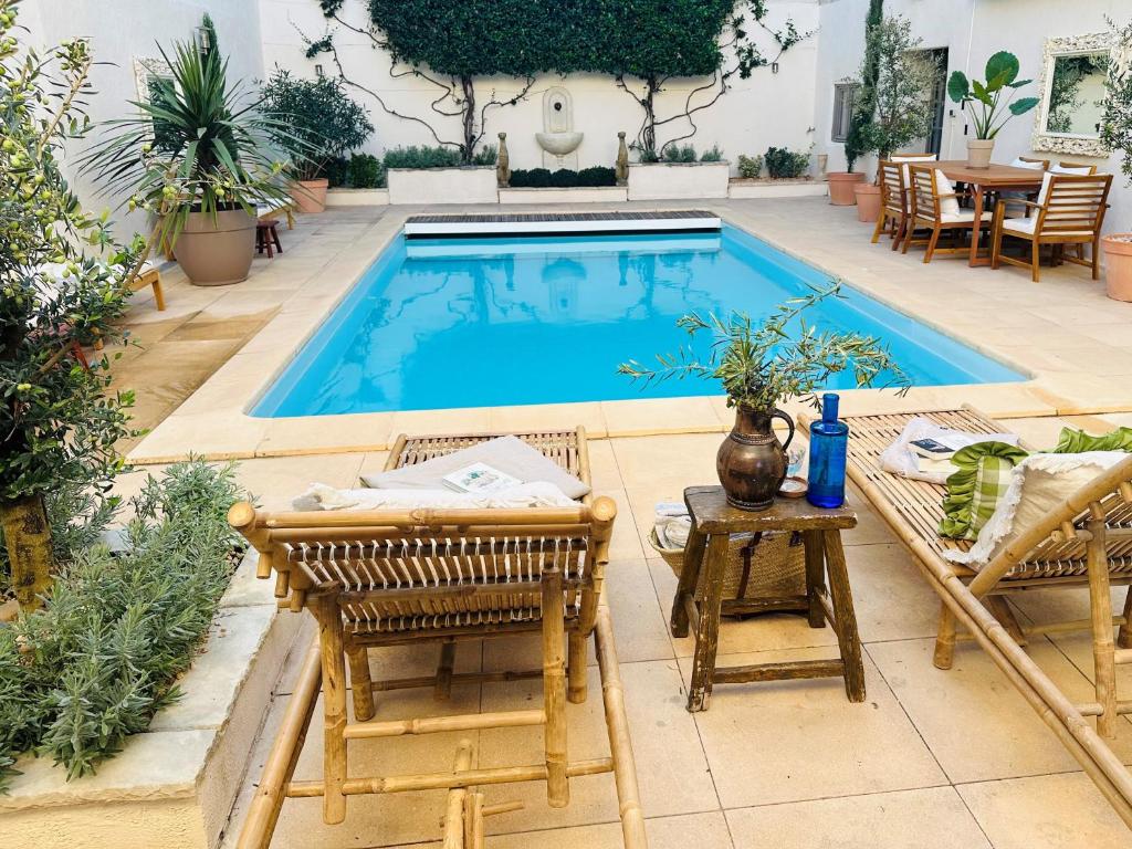 - une piscine avec 2 chaises, une table et une table dans l'établissement Beautiful and spacious 3 bed character home with large, private heated pool, à Pouzolles