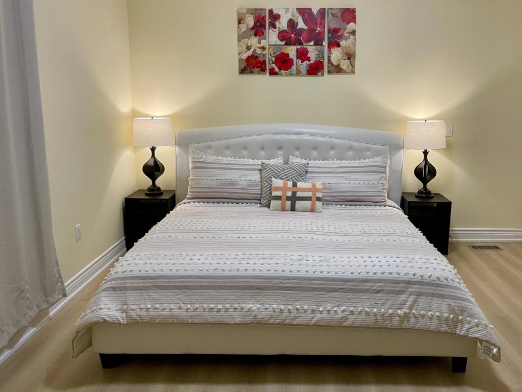 a bedroom with a large bed with two lamps at LuxuryCottage KingBed PrivateYard BBQ Deck Gazebo in Niagara Falls