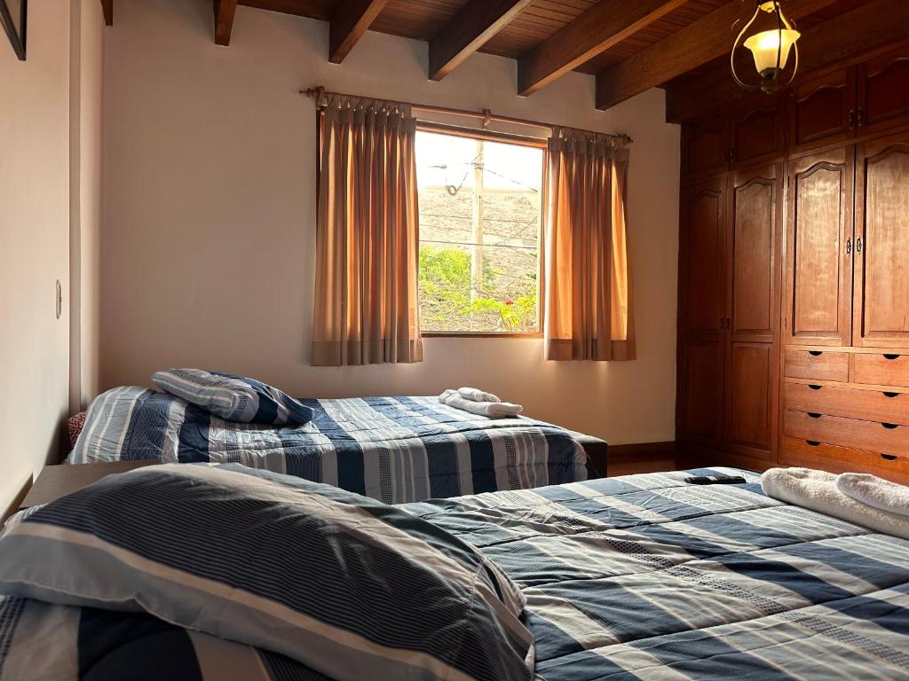 1 dormitorio con 2 camas y ventana en Habitacion doble vista a la Huaca Miraflores, en Lima