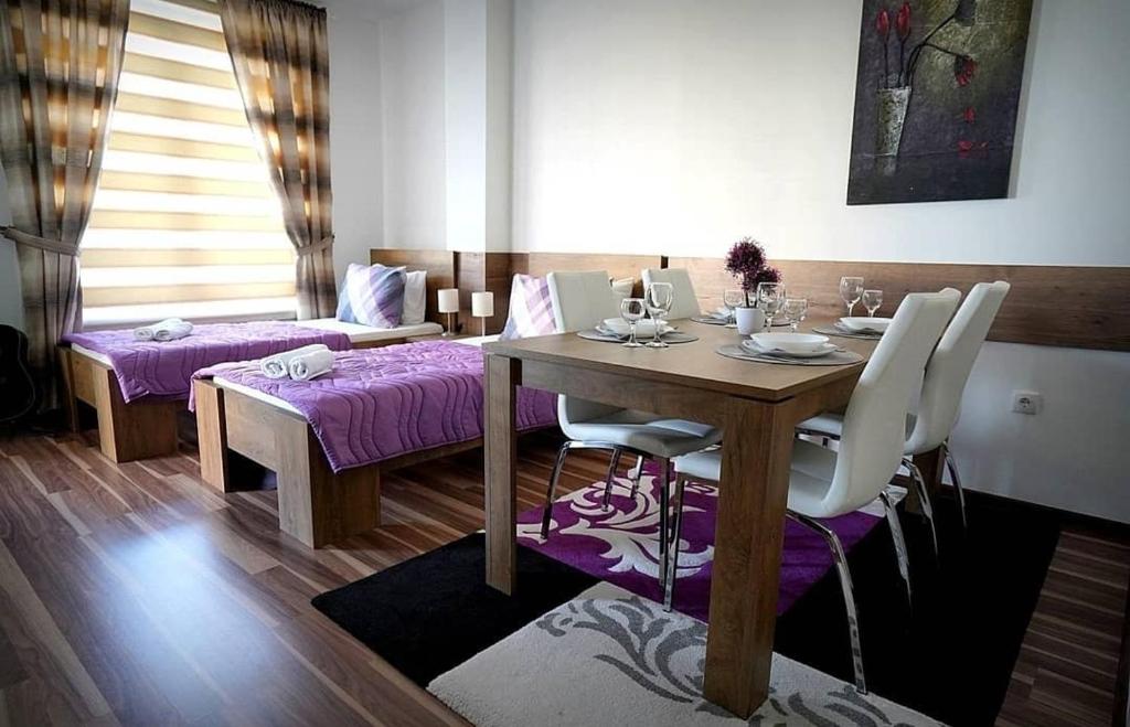 a dining room with a wooden table and purple chairs at Serbona apartment in Kladovo