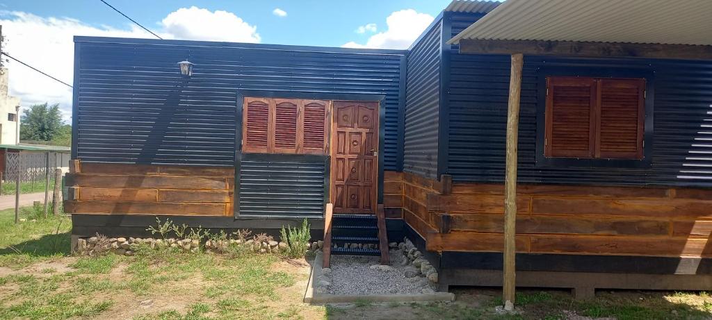 a blue house with two windows and a door at La Cautiva 225 in Villa del Dique