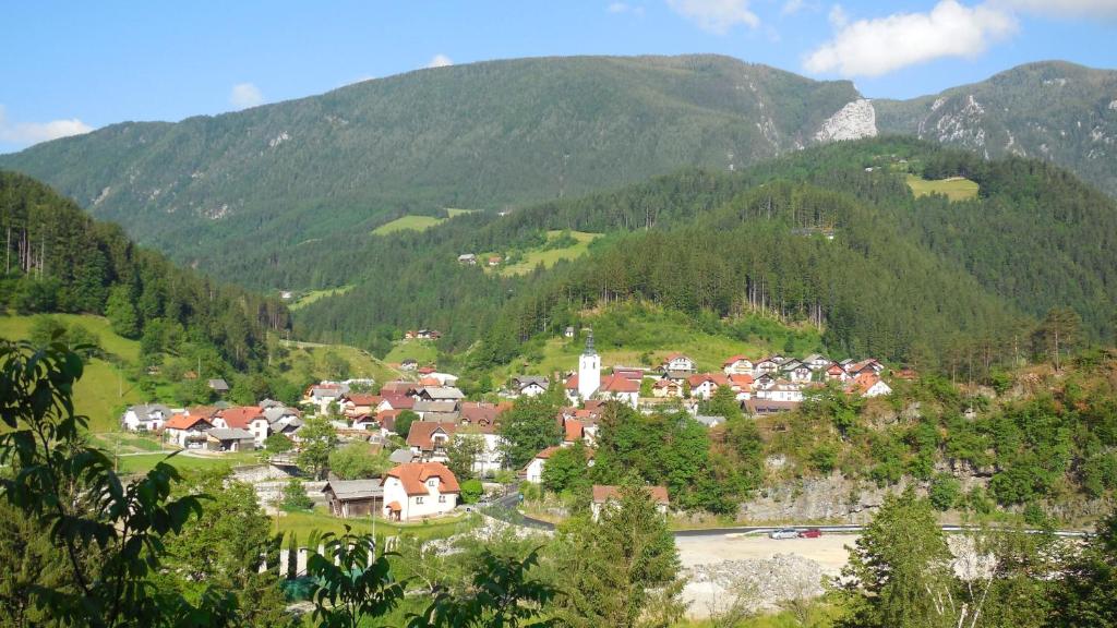 eine Stadt auf einem Hügel mit Bergen im Hintergrund in der Unterkunft Apartments Savinja in Luče