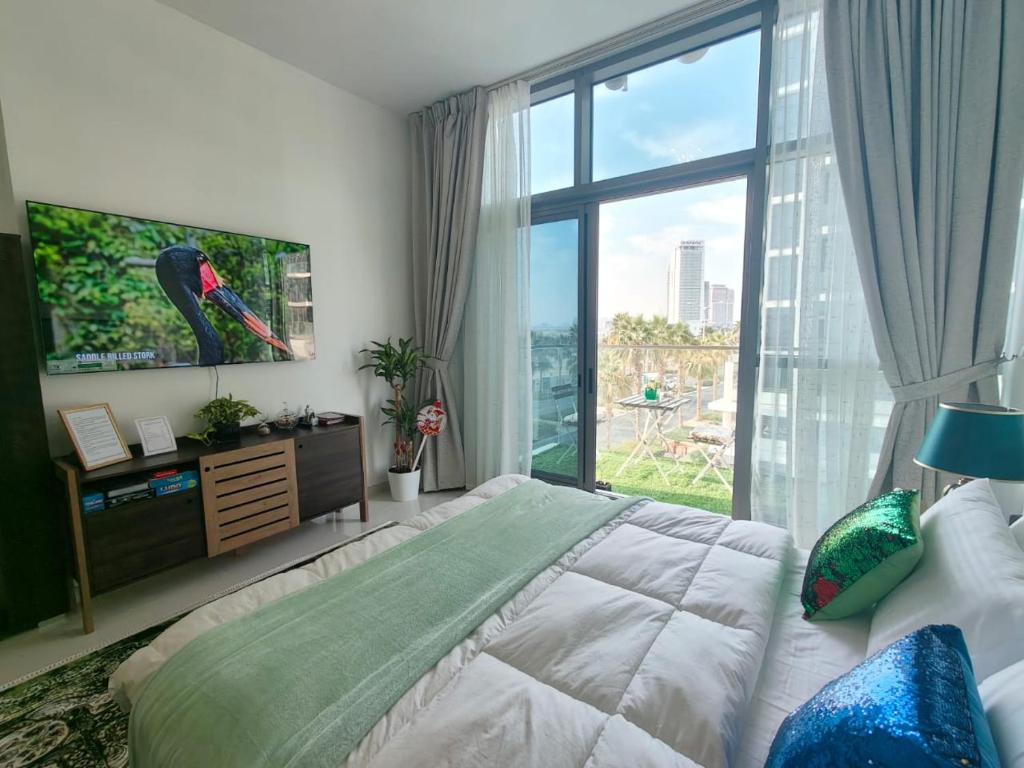Damac Hills Cozy Studio Apartment في دبي: غرفة نوم بسرير ونافذة كبيرة