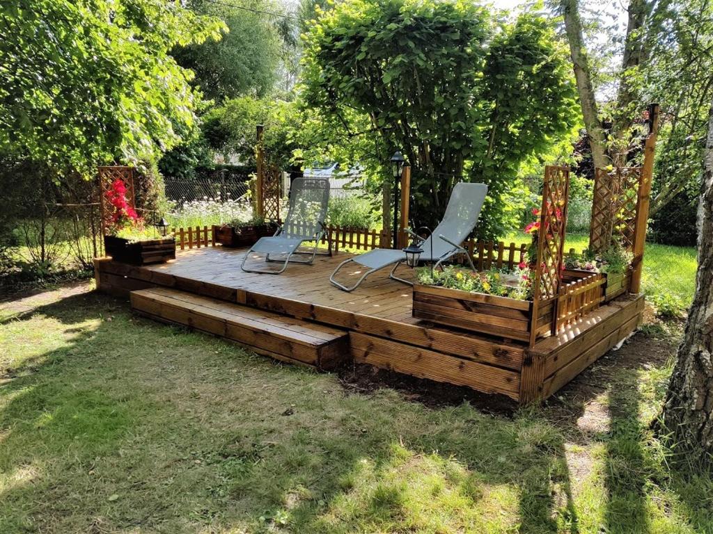 una terrazza in legno con 2 sedie in giardino di Gîte Les Hortensias a Vaas