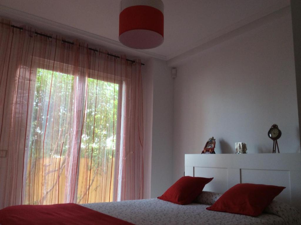 een slaapkamer met een bed en een groot raam bij Apartamento turístico 2 hab. in Vera