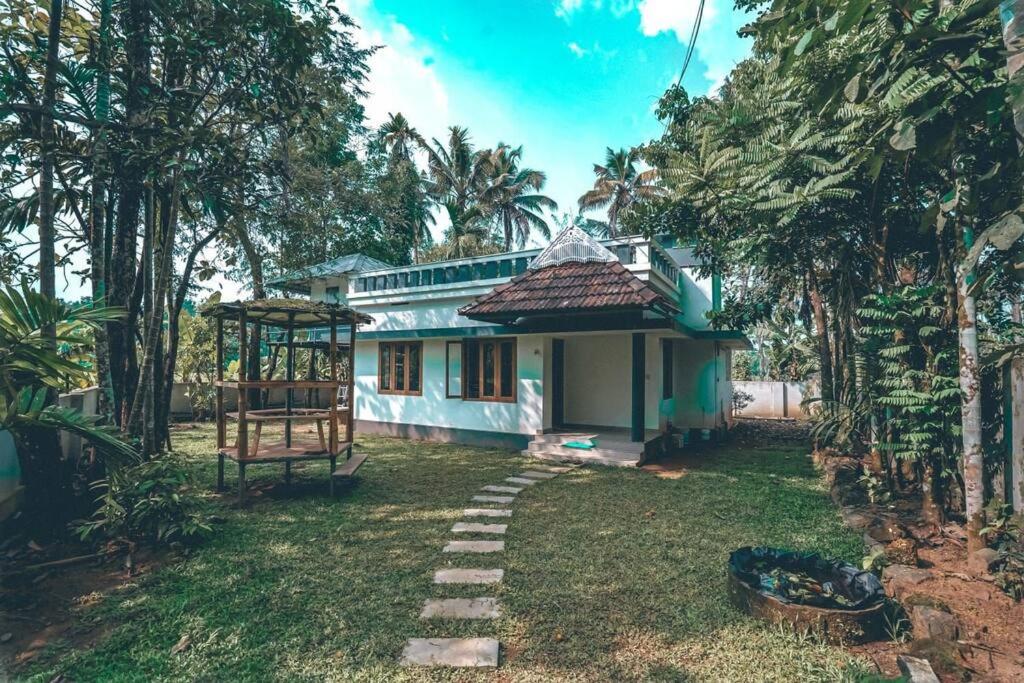 una casa con un camino delante de ella en Paddy N Pond Tree house Villa 2R, en Angamaly