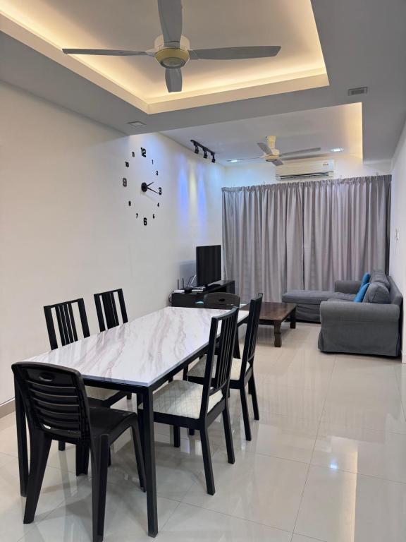 a dining room with a table and chairs and a couch at Sandakan IJM condo full-equipped homestay in Sandakan